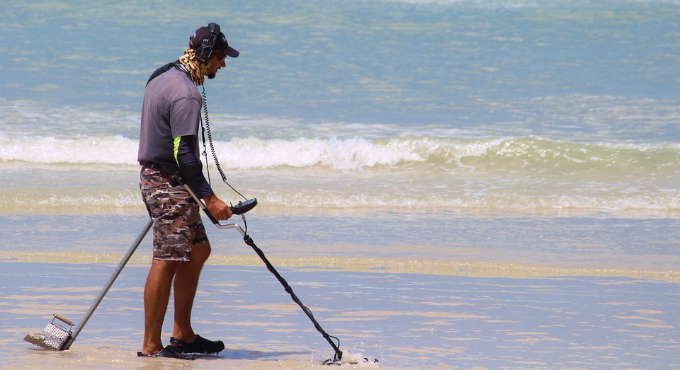 a man looking for metals at a beach